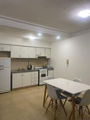a kitchen with white cabinets and a table and chairs at Mar in Junín