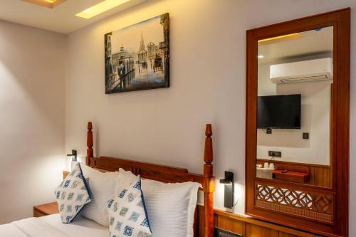 a bedroom with a bed with a mirror and a television at Ra Vista in kolkata