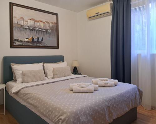a bedroom with a bed with two towels on it at Saint Nicholas Varna Lovely 2 bedroom apartment with sunny garden in Varna City