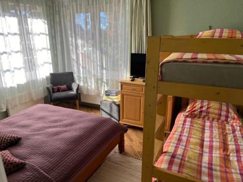 a bedroom with two bunk beds and a chair at Family house room in Salacgrīva