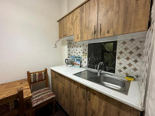 uma cozinha com um lavatório e armários de madeira em Buhara Family Stone House em Istambul