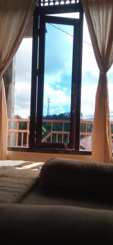 a bedroom with a window and a bed with a view at Toraja Bungin Homestay in Rantepao