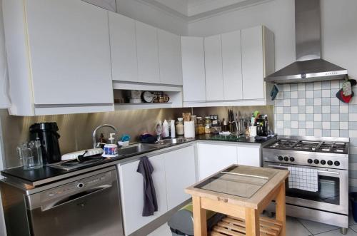 une cuisine avec des armoires blanches et un four à plaques de cuisson dans l'établissement The Place to B&B, à Huelgoat