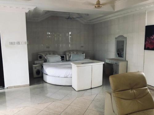 ein Schlafzimmer mit einem Bett und einem Stuhl darin in der Unterkunft Crislord Palace Hotel in Takoradi