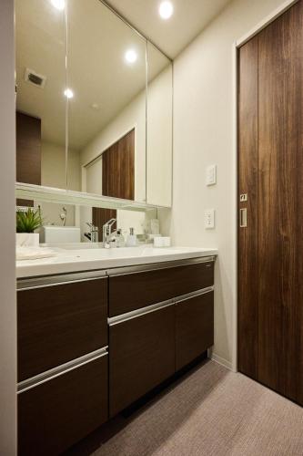 a bathroom with a sink and a large mirror at Casa YONNA Naha in Naha