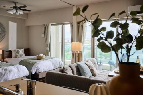 a living room with a couch and a bed at Casa YONNA Naha in Naha