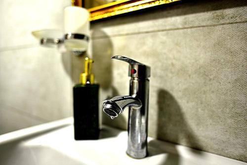 un lavandino in bagno con rubinetto e una bottiglia di sapone di Chalet Resort Weekend Borjomi a Borjomi
