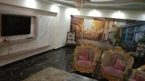 - un salon inondé avec 2 chaises et une télévision à écran plat dans l'établissement زهراء المعادي الطريق الدائري بجوار مودرن اكاديمي وكارفور, au Caire