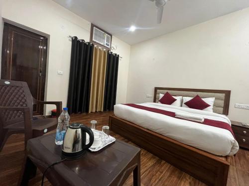 une chambre d'hôtel avec un lit et une table avec un téléphone dans l'établissement Hotel Badal Inn - Safdarjung Enclave, à New Delhi