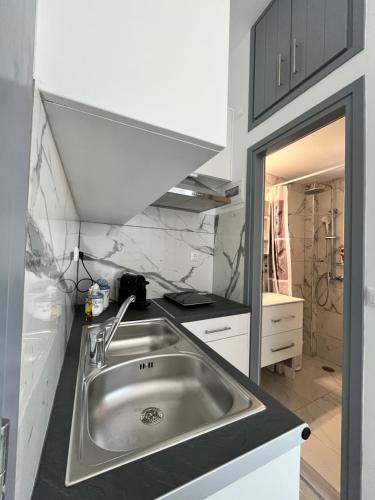 cocina con lavabo de acero inoxidable y espejo en Aegean Pearl Studio, en Tinos