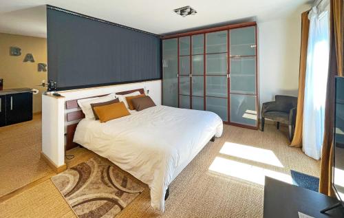 - une chambre avec un grand lit blanc et un mur bleu dans l'établissement Le Jardin de Celina, à Valensole