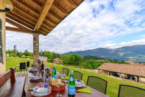 stół z jedzeniem i napojami na patio z widokiem w obiekcie Oasi di Castelveccana Apt Pool and View w mieście Castelveccana