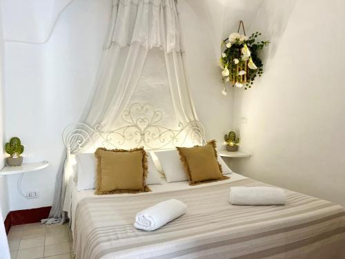 a white bed with two pillows on top of it at Dimora Antica Perla in Fasano