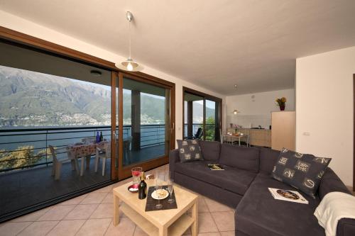 ein Wohnzimmer mit einem Sofa und einem Tisch in der Unterkunft Va Pensiero sul lago Stunning View in Tronzano Lago Maggiore