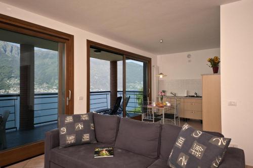 ein Wohnzimmer mit Sofa und Blick auf eine Küche in der Unterkunft Va Pensiero sul lago Stunning View in Tronzano Lago Maggiore