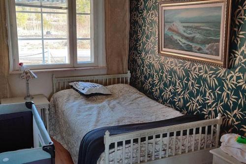 un pequeño dormitorio con una cama y una pintura en la pared en Talo rannan läheisyydessä, en Karvsor