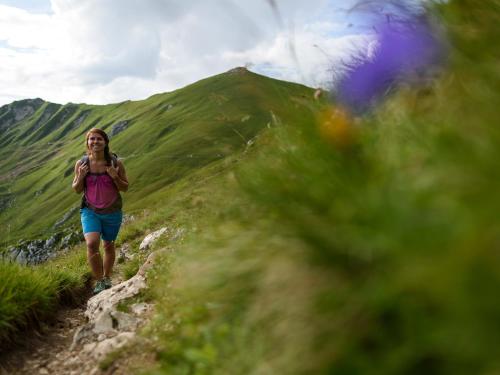 a woman walking down a trail on a hill at Natur- und Aktivresort Reiterhof in Achenkirch