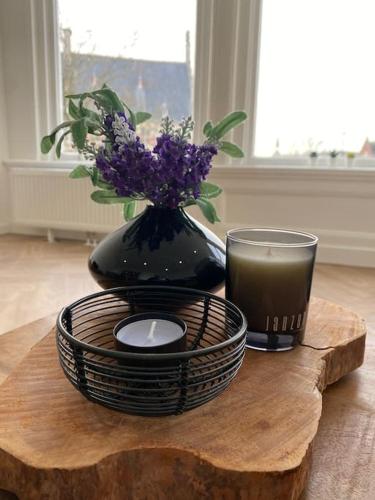 a table with a candle and a vase with flowers at Apartement City Center Gouda: View Deluxe in Gouda