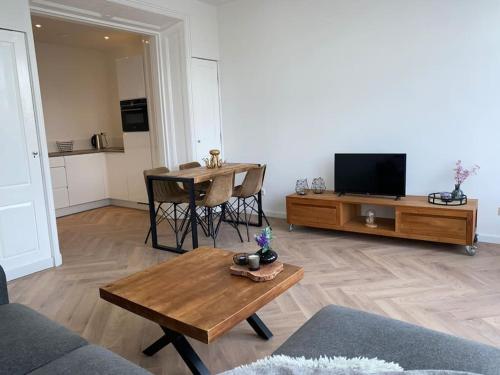 a living room with a table and a tv at Apartement City Center Gouda: View Deluxe in Gouda