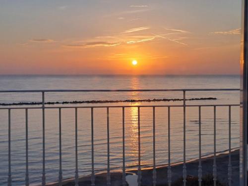 un tramonto sull'oceano dal balcone di un condominio di Attico fronte mare a Martinsicuro