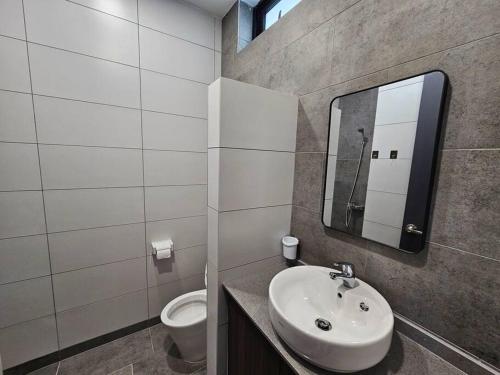 ein Bad mit einem Waschbecken und einem WC in der Unterkunft Lovely Podium CityView 3Bedroom with Pool A1 in Kuching