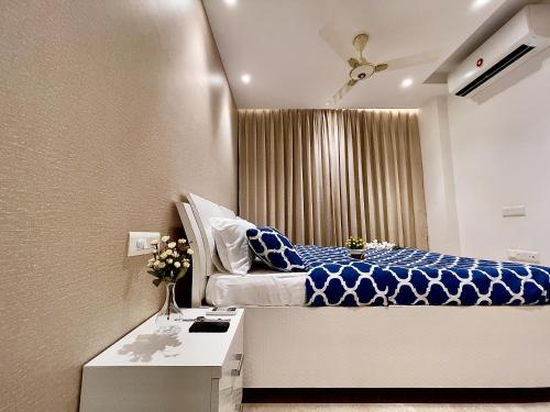 a bedroom with a blue and white bed and a window at City Nest 1 BHK in Hiranandani Powai (C) in Mumbai