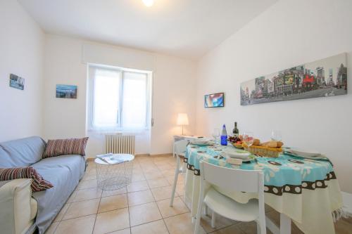 ein Wohnzimmer mit einem Tisch und einem Sofa in der Unterkunft Casa Al Caprifoglio 600 Mt From Beach - Happy Rentals in Ispra