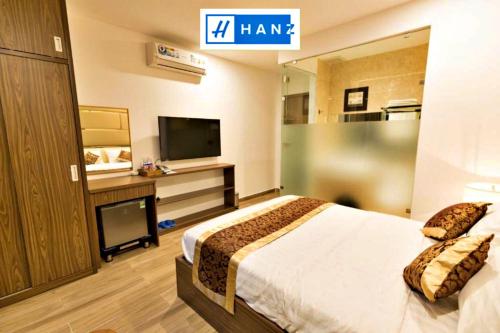 Habitación de hotel con cama y TV de pantalla plana. en HANZ MyMy Hotel en Ho Chi Minh