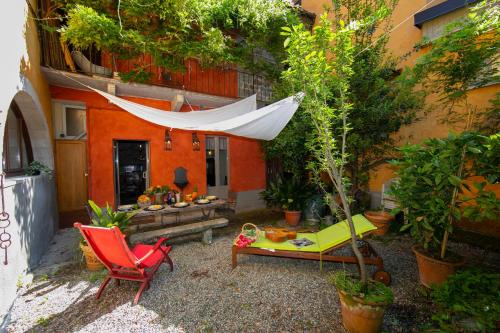 a patio with a hammock and a table and chairs at Residenza Il Glicine di Lesa in Lesa