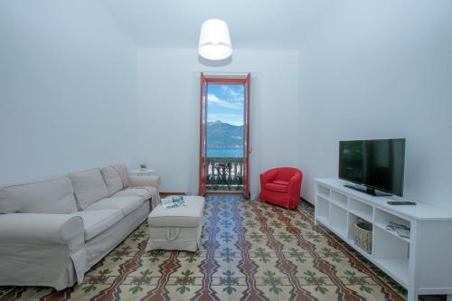 a living room with a couch and a tv at Residenza Oleandro Lake View Luino Center in Luino