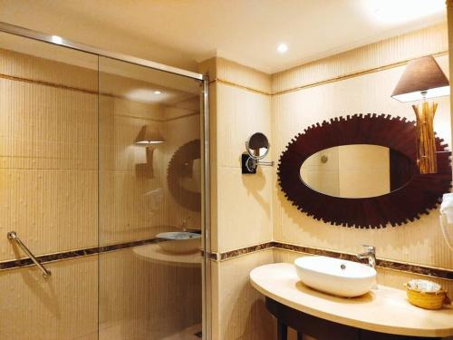 a bathroom with a sink and a shower and a mirror at Amarina Jannah Resort & Aqua Park in Coraya Bay