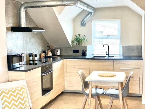 una cucina con un tavolo, una stufa e un lavandino di Palms 2 - Central, 5 mins walk to beach + parking! a Newquay