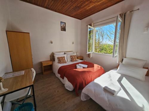 a bedroom with two beds and a window at Hôtel Au Bon Landais in Biscarrosse-Plage