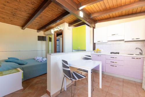 a kitchen with a table and chairs and a bed at Room and Breakfast Aloe in San Vito lo Capo