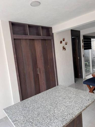 a kitchen with a counter and a wooden door at Bonita casa nueva con alberca climatizada y aire acondicionado en Oaxtepec Morelos in Oaxtepec