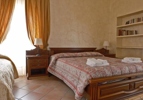 a bedroom with a bed with two towels on it at Conte Spencer in Casertavecchia