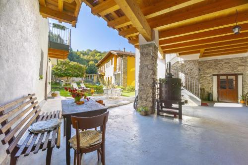 een patio met een tafel en stoelen en een bank bij Casa Baroni few min from Orta Lake in Madonna del Sasso