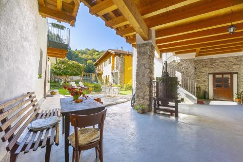 patio ze stołem, krzesłami i ławką w obiekcie Casa Baroni few min from Orta Lake - Happy Rentals w mieście Madonna del Sasso