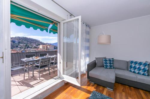 een woonkamer met een bank en een balkon bij Appartamento Il Golfo Lake View in Laveno