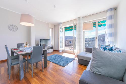 een woonkamer met een tafel en een eetkamer bij Appartamento Il Golfo Lake View in Laveno