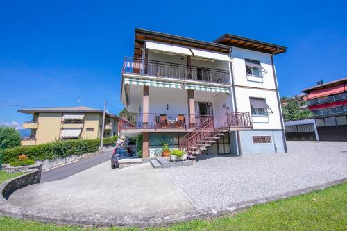 - un grand bâtiment blanc avec un balcon et des escaliers dans l'établissement Casa Angiolina Bellavista, à Besozzo