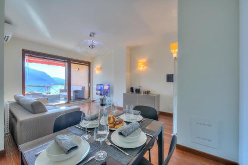 a dining room with a table and a couch at Panorama Fantastico Apt Pool & Beach - Happy Rentals in Ghiffa