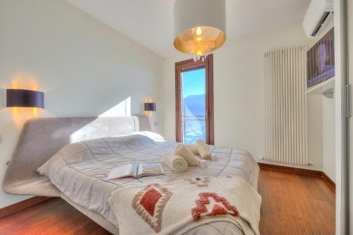 a bedroom with a bed with towels and a window at Panorama Fantastico Apt Pool & Beach - Happy Rentals in Ghiffa