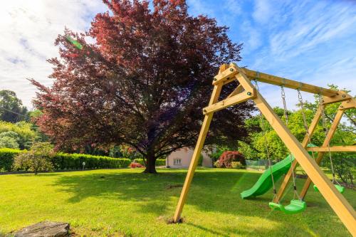 a swing set in a park with a tree at Villa Giulietta Family Child Friendly - Happy Rentals in Gemonio