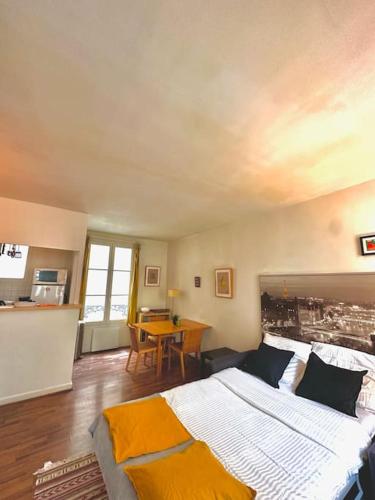 une chambre avec un grand lit et une table dans l'établissement Cozy 1BR in the Heart Of Paris, à Paris