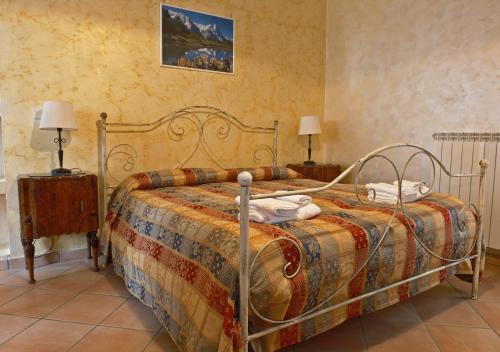 a bedroom with a bed with a metal frame and two lamps at Conte Spencer in Casertavecchia