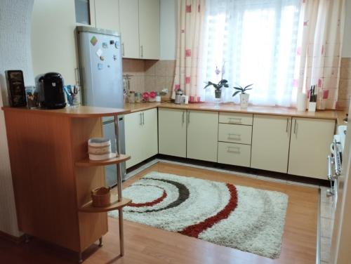 uma cozinha com armários brancos e um tapete no chão em Apartman Unac em Drvar