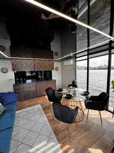 ein Wohnzimmer mit einem Tisch und Stühlen auf einem Boot in der Unterkunft Houseboat EnergyApart in Stettin
