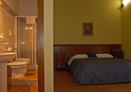 a bedroom with a bed and a bathroom with a toilet at Conte Spencer in Casertavecchia