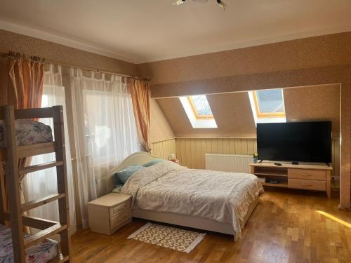 um quarto com uma cama e uma televisão de ecrã plano em Family House Apartments em Salacgrīva